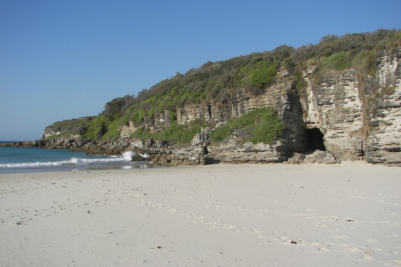 Pale sand and turquoise water at Cave Beach in Booderee National Park, Jervis Bay, a sheltered bay after a stretch of open coast.