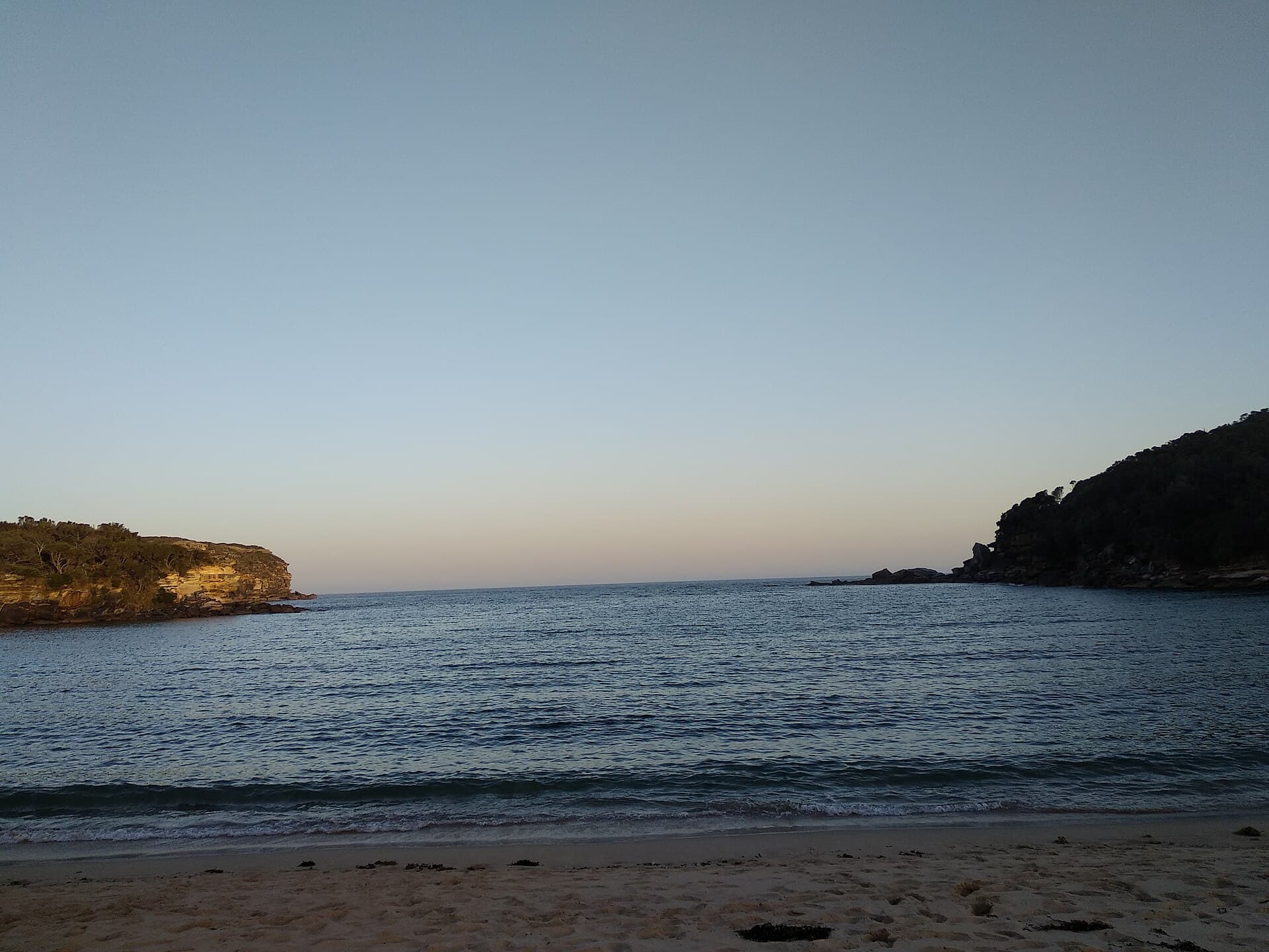 The lagoon and sandstone at Wattamolla in Royal National Park, a still pool under an open sky south of Sydney.