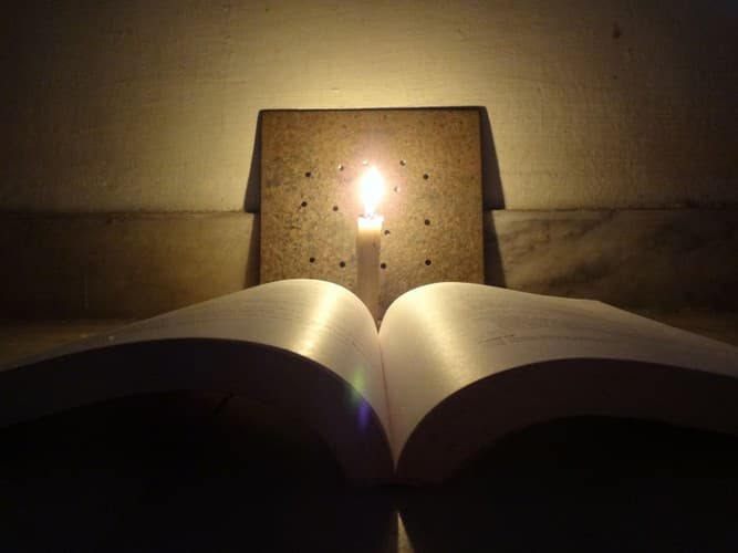 An open paperback on a timber table, the pages slightly curved as if someone has just set it down.